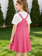 Back view of girls waffle overall dress with adjustable shoulder straps and layered T shirt styling, comfortable kids outfit design.