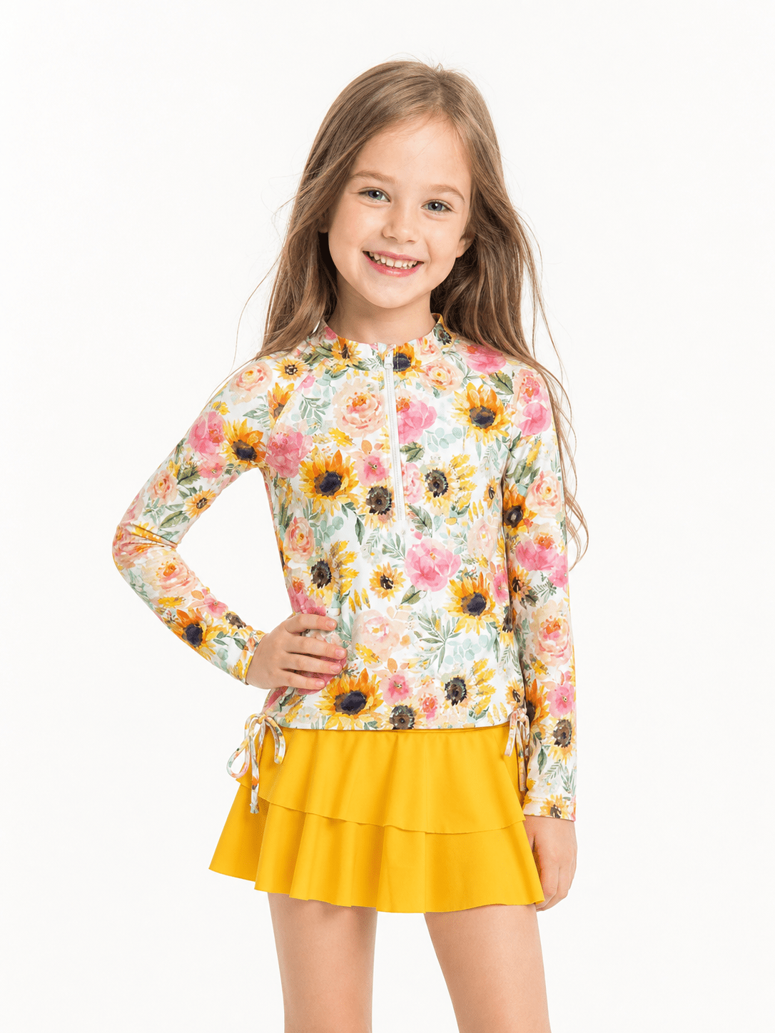 Girl wearing a Yellow Sunflowers long sleeve rash guard swimsuit set with matching bottoms and skirt, showing the front fit and printed swimwear design on a white background.