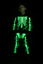 Kids black skeleton costume shown in the dark with glowing green bone print on the hooded top and matching pants.