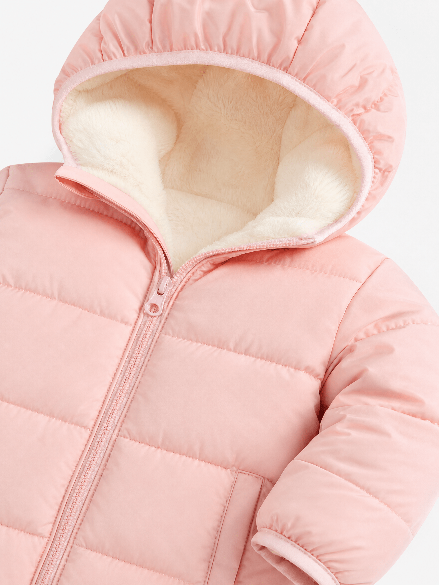 Close-up of a pink hooded puffer jacket showing the soft fleece-lined hood, quilted construction and full front zipper.