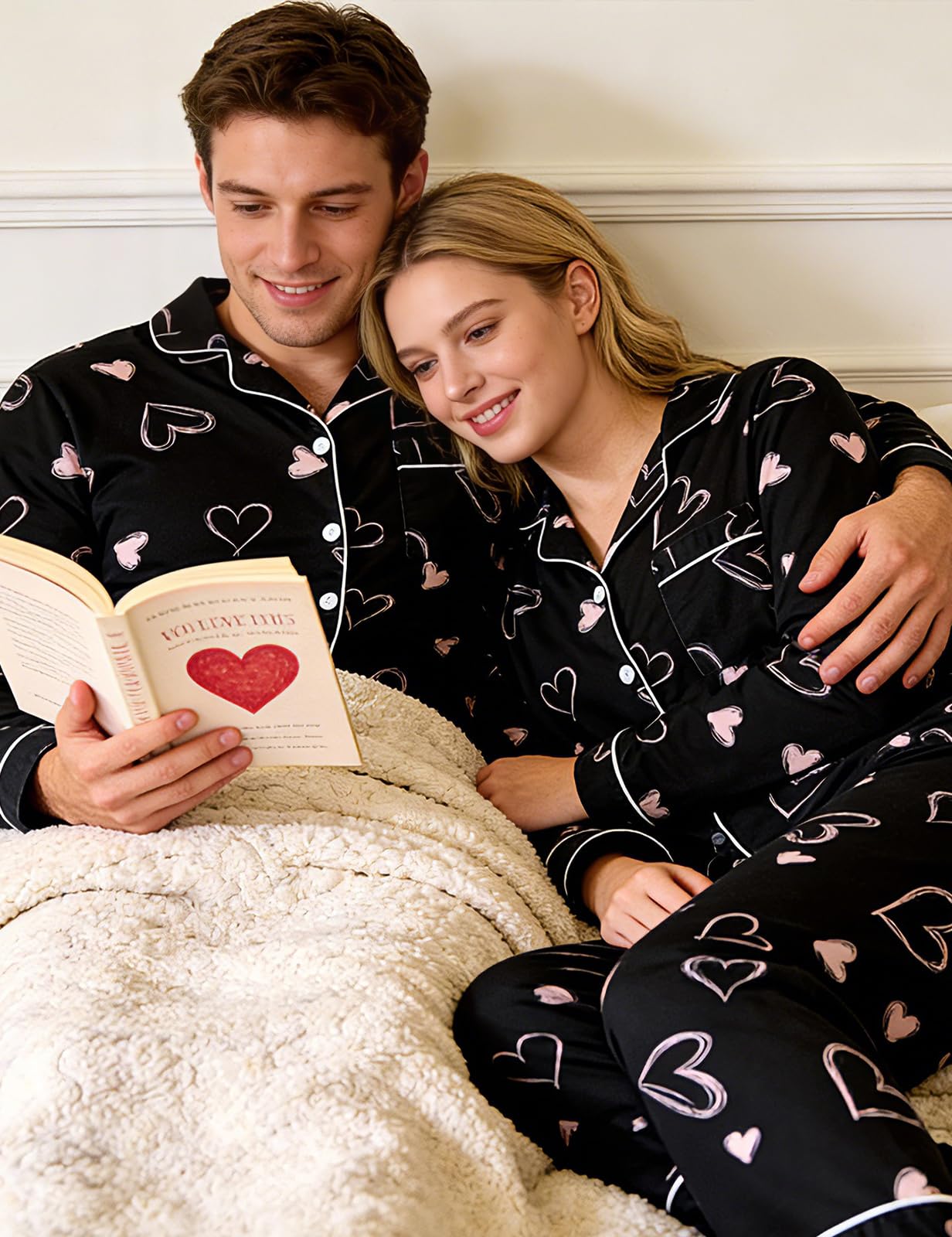 Couple wearing matching black heart pajama sets while relaxing together at home, styled for cozy nights and comfortable lounging.