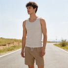 Man wearing linen blend drawstring shorts with a casual summer tank top, lightweight vacation outfit for outdoor activities and warm weather.