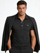 Male model wearing a black performance polo shirt with casual everyday styling.