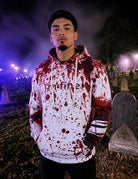 Man wearing a Blood Splatter horror graphic hoodie at night, showing the relaxed fit, hooded design and vivid red print.