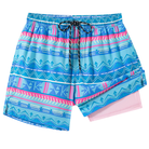 Men's blue geometric print 2-in-1 swim trunks with drawstring waist and contrast compression liner, designed for beach and pool wear.
