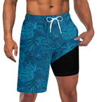 Men's blue palm leaf print swim trunks with built-in black compression liner and adjustable drawstring waist for beach activities.