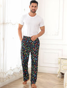Man wearing festive lounge pants indoors, showing comfortable full-length design for relaxing, sleeping and casual home wear.