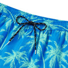 Close up of men's swim trunks showing the adjustable drawstring waistband, tropical print fabric and lightweight quick dry material.