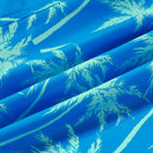 Close up details of men's swim trunks showing tropical print fabric texture, lightweight material and quick dry design.
