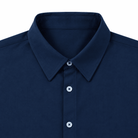 Close-up of boys navy polo shirt showing the polo collar, button front placket and clean stitching details.