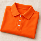 Close-up of the orange boys polo shirt showing the structured collar, button placket and smooth solid fabric construction.