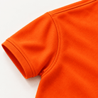 Close-up of the orange boys polo shirt showing the short sleeve edge, stitching and smooth lightweight fabric texture.