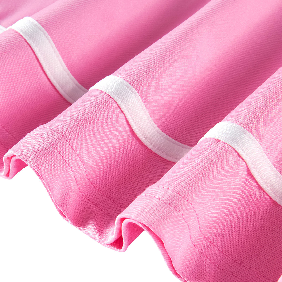 Close-up of the pink polo dress showing the long sleeve cuff, white contrast piping and softly flared hem construction.