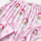 Close-up of pink Christmas pajama fabric showing Santa Claus graphics, snowflake prints and soft lightweight material details.