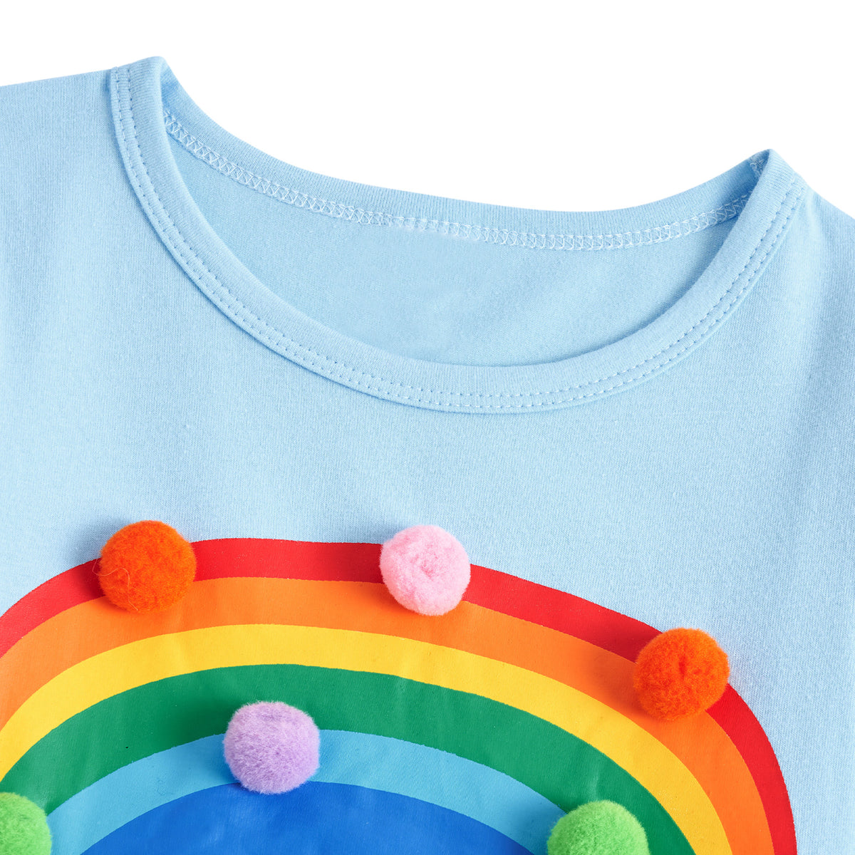 Close-up of the girls rainbow tulle dress showing the neckline, soft sleeve design and colorful rainbow decoration details.