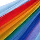 Close-up of the rainbow tulle dress showing the layered mesh skirt, colorful fabric texture and soft flowing design.