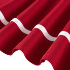 Close-up of the red girls polo dress showing the white contrast piping, long sleeve cuff and flared skirt hem details.