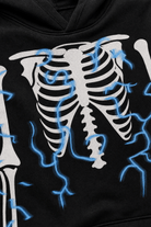 Close-up of kids black skeleton costume showing the detailed rib cage and bone print on the soft stretch fabric.