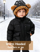 Toddler wearing a black puffer jacket with the plush bear-ear hood up, showing warm head and neck coverage for cold-weather outings.