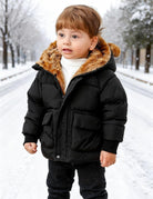 Toddler wearing a black bear ear puffer jacket outdoors in winter, showing the quilted front, full zipper and cozy hooded design.