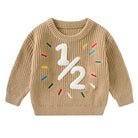 Toddler khaki knit sweater with raised white 1/2 birthday design and colorful embroidered accents for milestone photos and celebrations.